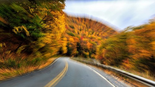 Curvy country road, downhill, autumn leaves, Indian summer, traveling, symbolic photo, zoom effect,