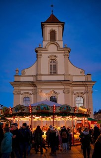 Carousel, catholic church of the Most Holy Trinity, people, visitors, baroque Christmas market,