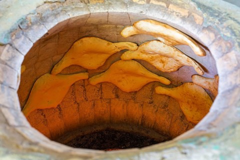 A traditional oven with several flatbreads in the baking process, Samtskhe-Javakheti region,