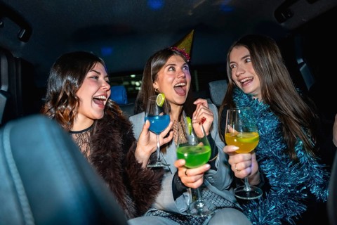 Three friends celebrating a special occasion, laughing and enjoying colorful cocktails while