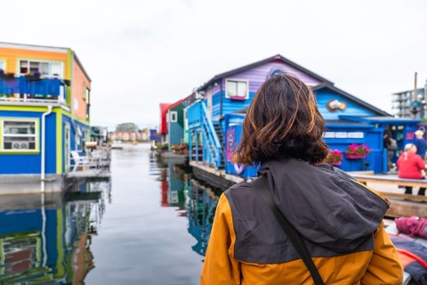 Tourist observing the colorful floating houses of fisherman's wharf park in victoria. British