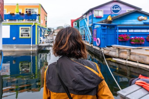 Tourist admiring the colorful floating houses of fisherman's wharf park, a popular tourist