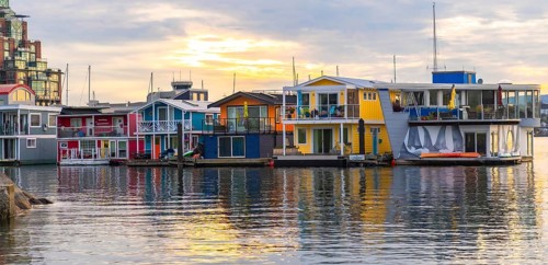 Colorful floating homes reflecting in the calm water at fisherman's wharf park in victoria, british