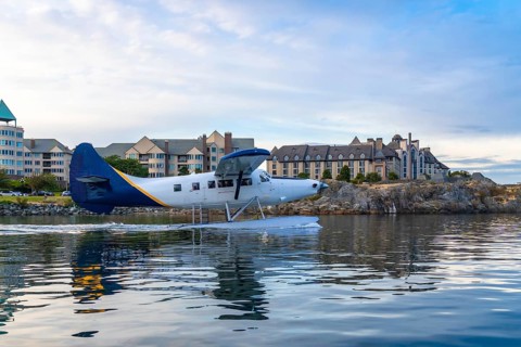 Seaplane taking off in the harbor of victoria, british columbia, with hotels and residential