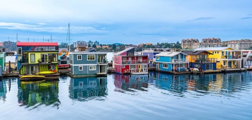 Fisherman's wharf park's vibrant houseboats create a picturesque scene, reflecting in the calm