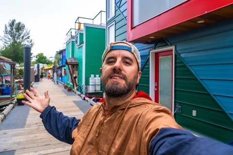 Tourist taking a selfie and showing colorful floating homes in fisherman's wharf park, a popular
