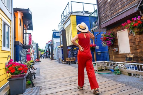 Tourist wearing a straw hat and a red jumpsuit walking in fisherman's wharf park, a colorful