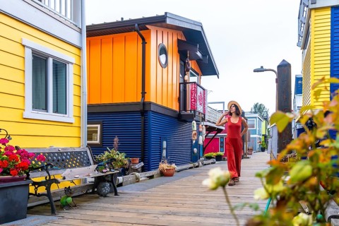 Tourist walking on a wooden walkway. Wearing a straw hat and a red jumpsuit. Exploring the colorful