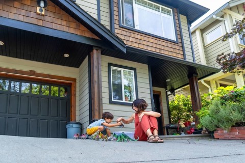 Mother and son bonding over dinosaur toys, enjoying quality time together on the driveway of their