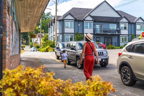 Mother and son enjoying a leisurely stroll along a charming sidewalk in chemainus, surrounded by
