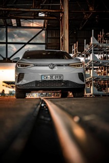 White car in front of warehouse structure at sunset on rails, VW ID4 electric car, Deer Carsharing,