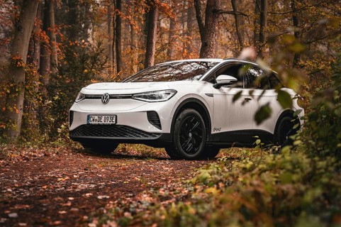 White car parked in forest surrounded by autumn leaves, VW ID4 electric car, Deer Carsharing, Calw,