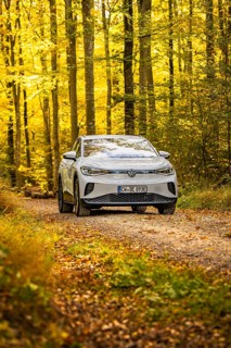 White car on a forest path surrounded by autumn leaves, VW ID4 electric car, Deer Carsharing, Calw,