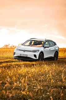A white Volkswagen SUV on a sunlit meadow, VW ID4 electric car, Deer Carsharing, Calw, Germany