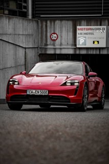 Red Porsche Taycan stands in front of a modern building on paved area, Porsche Taycan, Deer