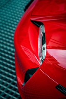 Close-up of the front end of a red Porsche with focus on headlight design, Porsche Taycan, Deer