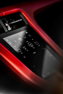 Close-up of car interior with red touchscreen control panel and modern displays, Porsche Taycan,