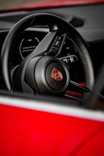 Close-up view of a Porsche steering wheel with modern design elements inside, Porsche Taycan, Deer