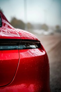 Close-up of a red Porsche with wet body and shiny rear light, Porsche Taycan, Deer Carsharing,