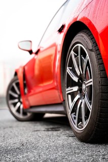 Side view of a red vehicle focusing on the front wheel, Porsche Taycan, Deer Carsharing, Calw,