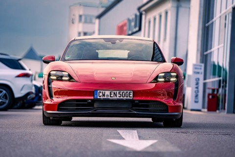 Red car of elegant design parked in an urban square, Porsche Taycan, Deer Carsharing. Calw, Germany