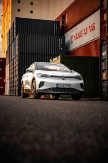 Silver car next to stacked containers at sunset, VW ID4 electric car, Deer Carsharing, Calw,