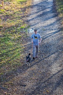 Washington, DC - A man walks his dog on the Kingman Island Trail. Kingman Island is in the