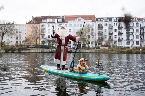 A water sports enthusiast dressed up as Santa Claus rides a SUP on the Spree in Berlin on 30.11