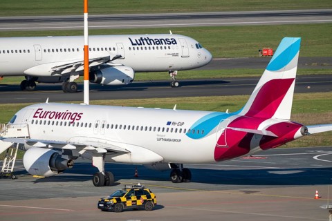 Lufthansa Airbus A321-200 on taxiway for takeoff, Eurowings Airbus parks outside position,
