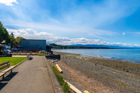Calm ocean waters lapping a pebbled shore at qualicum beach on vancouver island, british columbia,