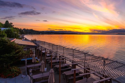 Golden sunset illuminating calm bay waters while reflecting vibrant evening sky colors over a