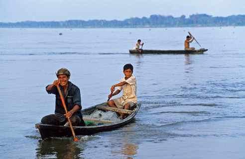 Father and son in a paddle boat on the Amazon near Iquitos, Peru, South America, September 1997,