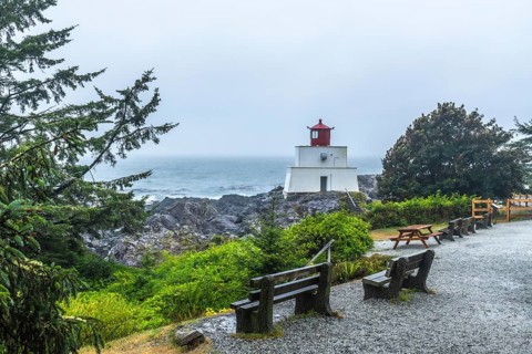 Amphitrite point lighthouse rising on the rocky ucluelet coast of vancouver island, british