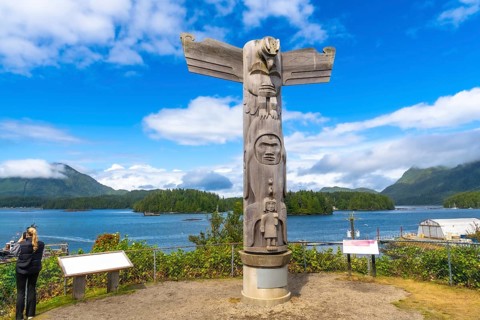 Wooden totem pole overlooking the ocean inlet in tofino, a small district on vancouver island in