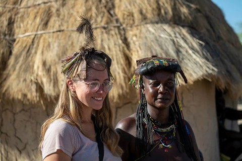Tourist and local in the village, Hakaona tribe, also Havakona or Hakawona, near Opuwo, Kunene,