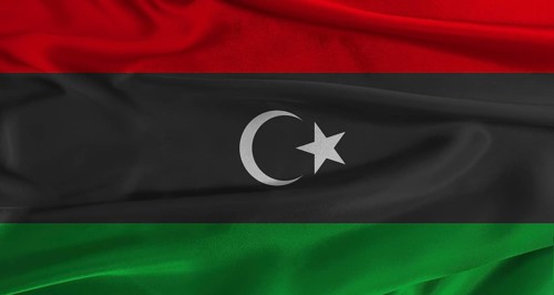 Flag of Libya with fabric textured background. Close up of National flag of Libya with realistic
