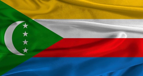 Flag of Comoros with fabric textured background. Close up of National flag of Comoros with