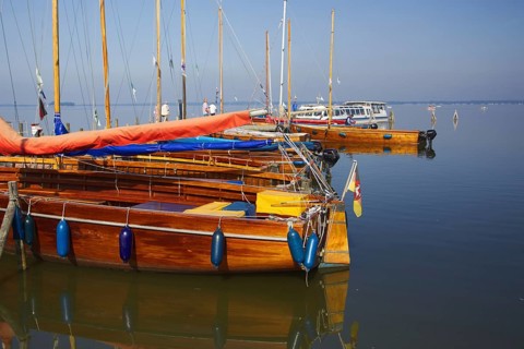 Several yachts are moored on the water in a quiet harbor, Steinhude Studer Meer