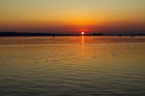 Sunset over a calm lake, orange sky, peaceful atmosphere, Steinhude Steinhuder Meer