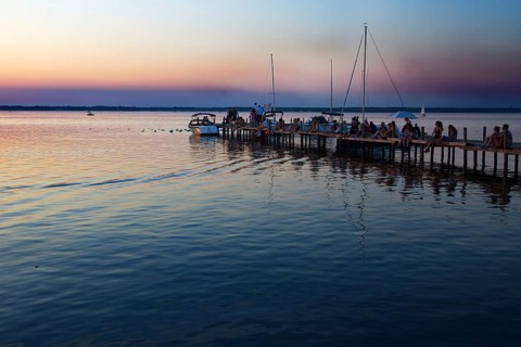 People sitting on a pier at sunset, boats at dusk, relaxed atmosphere, Steinhude, Steinhuder Meer