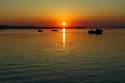 Sunset with several boats on Lake Steinhude, quiet evening mood, Steinhude