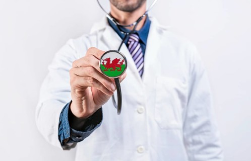 Wales healthcare system, doctor holding stethoscope. Wales health and medical insurance concept