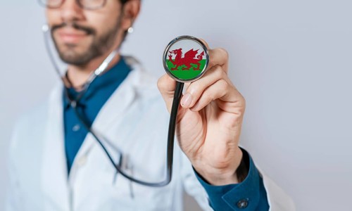 Doctor holding stethoscope with Wales flag. Wales health and care concept. Wales flag on