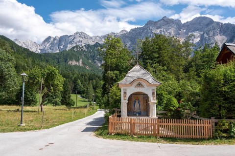 Small trail chapel with the Slovenian Alps in the background, mountaineering village Zgornje