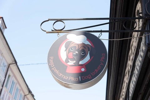 Round cantilever sign of the Pika dog bakery in the old town of Ljubljana, Slovenia