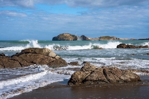 Castlepoint Beach and Castlepoint Lighthouse, ocean, waves, surf, sandy beach, rocks. Castlepoint,