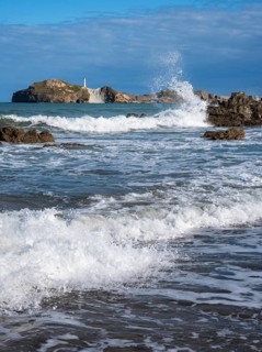 Castlepoint Beach and Castlepoint Lighthouse, ocean, waves, surf, sandy beach, rocks. Castlepoint,