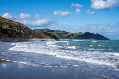 Castlepoint Beach, ocean, sandy beach, surf, mountains. Castlepoint, Wairarapa Coast, Wellington