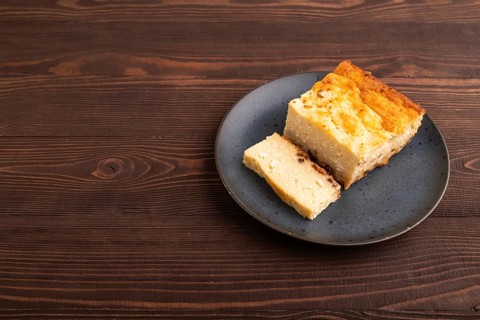 ?ottage cheese ?asserole, Curd cake, with dried apricots and raisins on brown wooden background,