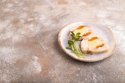 Chicken, egg and dried apricot meatloaf, microgreen on brown concrete background. side view, copy